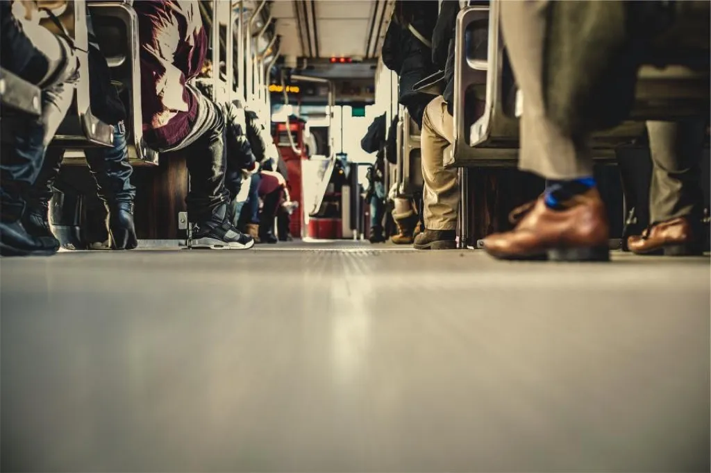 Standing passengers aboard a bus, photographed at floor level