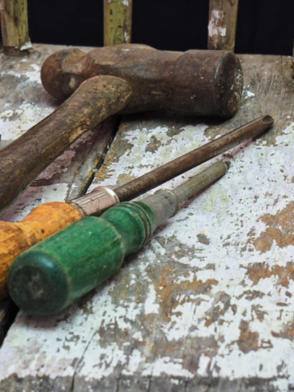 Hand tools resting on a worn workbench